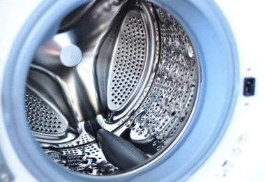 Bir çamaşır makinesi davul içinde çekim kapatın. Doku veya arka plan kullanın. Parlak metal delikli yüzey
