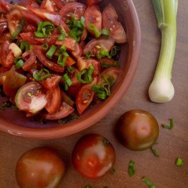domates salatası kahverengi masada, yeşil soğan ve bütün domates