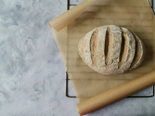 Pan de centeno de pan casero en la parrilla y papel de hornear —  Fotos de Stock