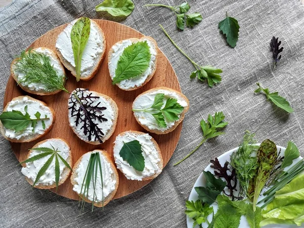 Bir çuval taze yeşillik ve yumuşak peynirli sandviçler.