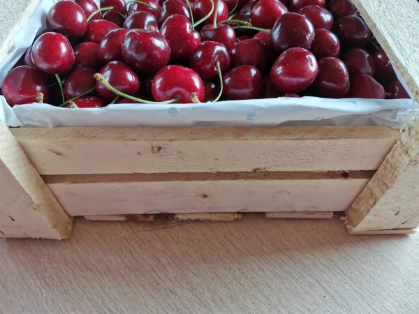 Na stole jest pełne pudełko czerwonych wiśni — Zdjęcie stockowe