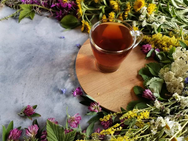 Una taza de té de hierbas en una bandeja de madera en la mesa gris — Foto de Stock