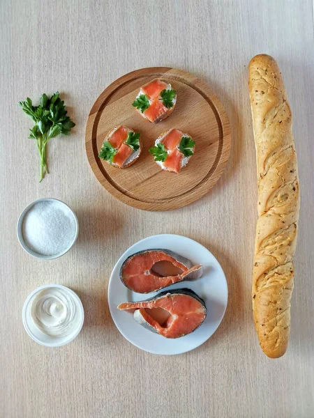 Knolling Concept slices of red fish homemade salt on a white plate and sandwiches with her