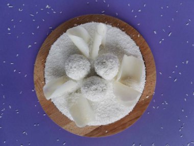 Hindistan cevizli kek ve eflatun arkaplanlı beyaz çikolata. Hindistan cevizi parçacıkları serpiştirilmiş.