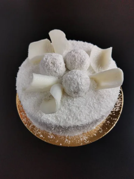 Siyah arka planda beyaz çikolatalı güzel hindistan cevizli kek. 