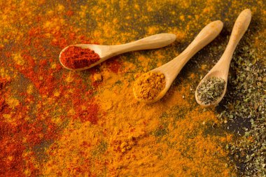 Baharat ve otlar karanlık bir arka plan üzerinde. Kırmızı biber, curcuma, chili biber, maydanoz, fesleğen, kekik. Yemek ve sağlıklı beslenme kavramı, seçici odak