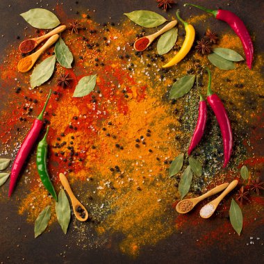 Otlar ve baharatlar seçimi (zerdeçal, kırmızı biber, defne yaprağı, tuz, biber biber) karanlık rustik arka planda, üstten görünüm