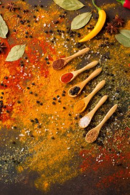 Otlar ve baharatlar seçimi (zerdeçal, kırmızı biber, defne yaprağı, tuz, yetkin) karanlık rustik arka planda, üstten görünüm