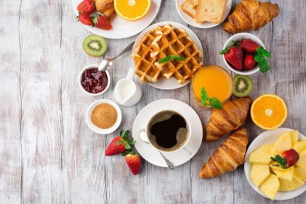 Tabulka kontinentální snídani s kávou, džusem, croissant — Stock fotografie
