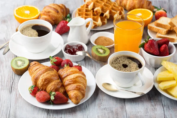 Mesa de pequeno-almoço continental com café, sumo de laranja, croissant — Fotografia de Stock