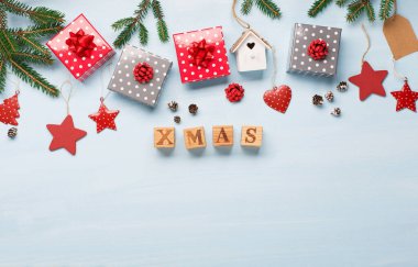 Çeşitli Noel ya da yeni yıl tatilleri çevre dostu dekorasyonlar, hediyeler ve köknar dalları. Çevre dostu dekor için fikirler. Düz yerde, üst tarafta. Mavi ahşap arka plan. Tahta küplerden yapılmış 