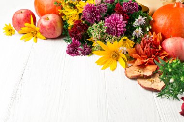 Çiçekler, yapraklar, beyaz ahşap arka planda balkabakları olan sonbahar kompozisyonu. Şükran Günü ya da diğer tatiller için sonbahar konsepti. Boşluğu kopyala.