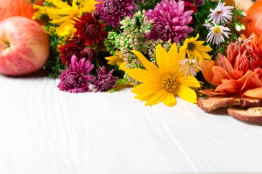 Çiçekler, yapraklar, beyaz ahşap arka planda balkabakları olan sonbahar kompozisyonu. Şükran Günü ya da diğer tatiller için sonbahar konsepti. Boşluğu kopyala.