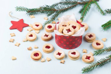 Linzer Noel ya da yeni yıl kurabiyeleri reçelle doldurulmuş ve mavi arka planda şekerle tozlanmış. Geleneksel Avusturya Noel kurabiyeleri. Kutuda ev yapımı tatlı bir hediye. DIY hediye konsepti.