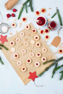Linzer Noel ya da yeni yıl kurabiyeleri reçelle doldurulmuş ve mavi arka planda şekerle tozlanmış. Geleneksel Avusturya Noel kurabiyeleri. Şenlik dekorasyonu. Üst görünüm.