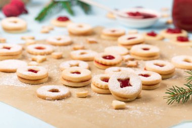 Linzer Noel ya da yeni yıl kurabiyeleri reçelle doldurulmuş ve mavi arka planda şekerle tozlanmış. Geleneksel Avusturya Noel kurabiyeleri. Şenlik dekorasyonu. DIY hediye konsepti.