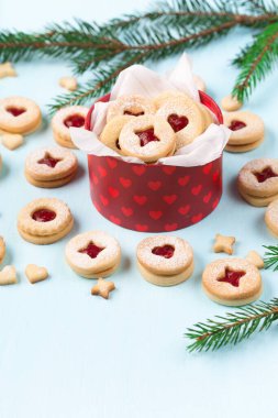 Linzer Noel ya da yeni yıl kurabiyeleri reçelle doldurulmuş ve mavi arka planda şekerle tozlanmış. Geleneksel Avusturya Noel kurabiyeleri. Kutuda ev yapımı tatlı bir hediye. Seçici odak.