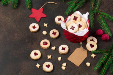 Linzer Noel ya da yeni yıl kurabiyeleri reçelle doldurulmuş ve koyu arkaplanda şekerle tozlanmış. Geleneksel Avusturya Noel kurabiyeleri. Kutuda ev yapımı tatlı bir hediye..