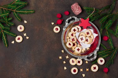 Linzer Noel ya da yeni yıl kurabiyeleri reçelle doldurulmuş ve koyu arkaplanda şekerle tozlanmış. Geleneksel Avusturya Noel kurabiyeleri. Kutuda ev yapımı tatlı bir hediye. Üst görünüm.