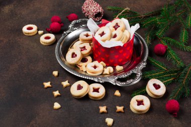 Linzer Noel ya da yeni yıl kurabiyeleri reçelle doldurulmuş ve koyu arkaplanda şekerle tozlanmış. Geleneksel Avusturya Noel kurabiyeleri. Kutuda ev yapımı tatlı bir hediye..