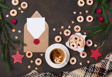 Geleneksel Avusturya Linzer Noel 'i, koyu arkaplanda reçel ve toz şekerle dolu yeni yıl kurabiyeleri. Kutu içinde ev yapımı tatlı bir hediye, el işi zarf, kart ve bir fincan kahve. Üst görünüm.