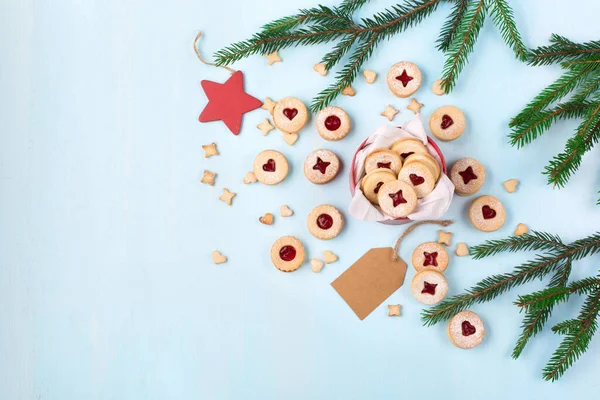 Linzer Noel ya da yeni yıl kurabiyeleri reçelle doldurulmuş ve mavi arka planda şekerle tozlanmış. Geleneksel Avusturya Noel kurabiyeleri. Kutuda ev yapımı tatlı bir hediye. Üst görünüm.