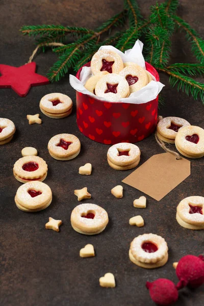 Linzer Noel ya da yeni yıl kurabiyeleri reçelle doldurulmuş ve koyu arkaplanda şekerle tozlanmış. Geleneksel Avusturya Noel kurabiyeleri. Kutuda ev yapımı tatlı bir hediye..