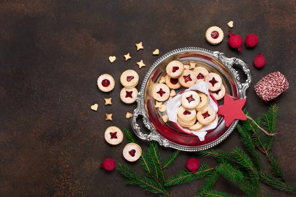 Linzer Noel ya da yeni yıl kurabiyeleri reçelle doldurulmuş ve koyu arkaplanda şekerle tozlanmış. Geleneksel Avusturya Noel kurabiyeleri. Kutuda ev yapımı tatlı bir hediye. Üst görünüm.