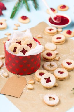 Linzer Noel ya da yeni yıl kurabiyeleri reçelle doldurulmuş ve mavi arka planda şekerle tozlanmış. Geleneksel Avusturya Noel kurabiyeleri. Kutuda ev yapımı tatlı bir hediye. Seçici odak.