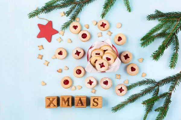 Linzer Noel ya da yeni yıl kurabiyeleri reçelle doldurulmuş ve mavi arka planda şekerle tozlanmış. Geleneksel Avusturya Noel kurabiyeleri. Kutuda ev yapımı tatlı bir hediye. Üst Manzara. DIY hediye konsepti
