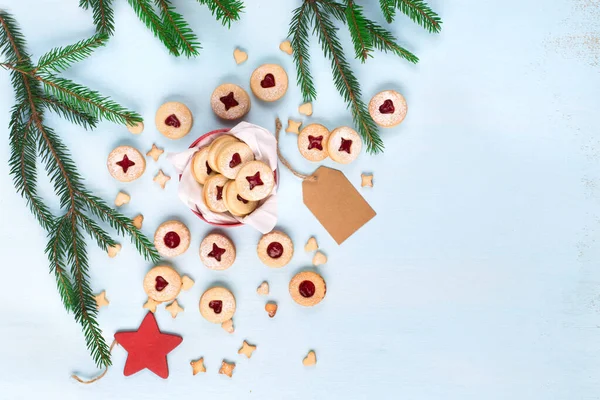 Linzer Noel ya da yeni yıl kurabiyeleri reçelle doldurulmuş ve mavi arka planda şekerle tozlanmış. Geleneksel Avusturya Noel kurabiyeleri. Kutuda ev yapımı tatlı bir hediye. Üst Manzara. DIY hediye konsepti