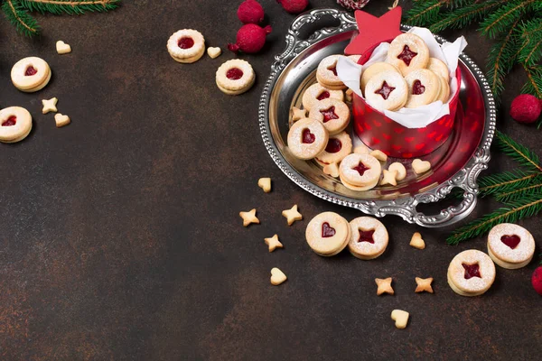 Linzer Noel ya da yeni yıl kurabiyeleri reçelle doldurulmuş ve koyu arkaplanda şekerle tozlanmış. Geleneksel Avusturya Noel kurabiyeleri. Kutuda ev yapımı tatlı bir hediye..