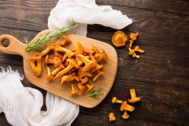 Eski ahşap arka planda taze Chanterelle mantarları ve otlar. Sonbahar sıcacık tatil yemekleri konsepti. Boşluğu kopyala.