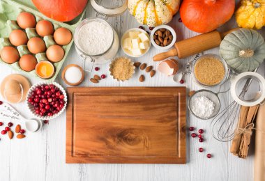 Sonbahar kış pişirme konsepti. Malzemeler, baharatlar ve çatal bıçaklarla yemek pişirmek. Geleneksel sonbahar kış turtası, kırsal beyaz ahşap arka plan, kopyalama alanı.