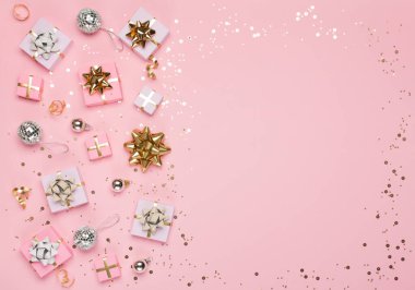 Noel kompozisyonu. Altın ve gümüş süslemeler, ayna disko topları, pastel pembe kağıt arka planda hediyeler. Noel, kış, yeni yıl konsepti. Düz konum, üst görünüm, kopyalama alanı.
