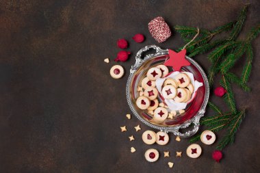 Linzer Noel ya da yeni yıl kurabiyeleri reçelle doldurulmuş ve koyu arkaplanda şekerle tozlanmış. Geleneksel Avusturya Noel kurabiyeleri. Kutuda ev yapımı tatlı bir hediye. Üst görünüm.