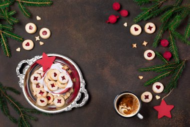 Linzer Noel ya da yeni yıl kurabiyeleri reçelle doldurulmuş ve koyu arkaplanda şekerle tozlanmış. Geleneksel Avusturya Xmas kurabiyeleri ve bir fincan kahve. Kutuda ev yapımı tatlı bir hediye. Üst görünüm.