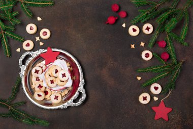 Linzer Noel ya da yeni yıl kurabiyeleri reçelle doldurulmuş ve koyu arkaplanda şekerle tozlanmış. Geleneksel Avusturya Noel kurabiyeleri. Kutuda ev yapımı tatlı bir hediye. Üst görünüm.