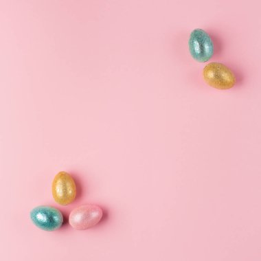 Pembe pastel arka planda altın, gümüş renkli Paskalya yumurtaları ve metin için boşluk. Düz konum resim kompozisyonu, üst görünüm. Paskalya dekorasyonu, folyo minimalist yumurta tasarımı, modern tasarım şablonu.