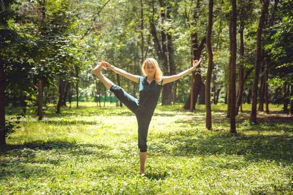 Utthita Hasta Padangustasana. Yoga asanas in nature. Yoga poses everyday. Practicing young woman. Yoga in the park