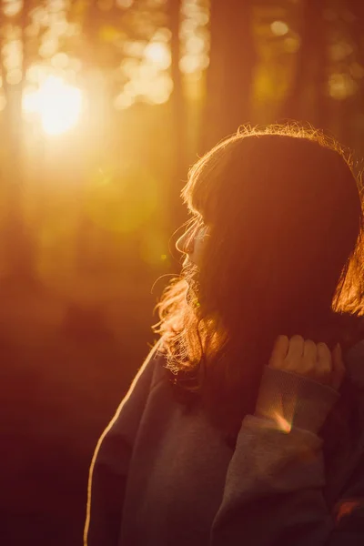 Das Mädchen im Wald beobachtet den Sonnenuntergang. Orangefarbene Sonne — Stockfoto