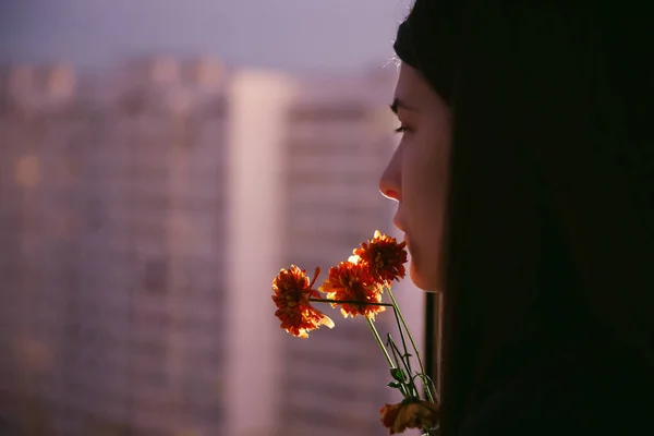 Joven belleza natural chica de pelo largo con flores en el balcón. Primavera. Buenas tardes. Zona de gran altura. Retrato. Estética. — Foto de Stock