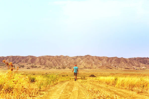 Joven viajero solitario camina vagando por la sabana caliente. Estilo de vida — Foto de Stock