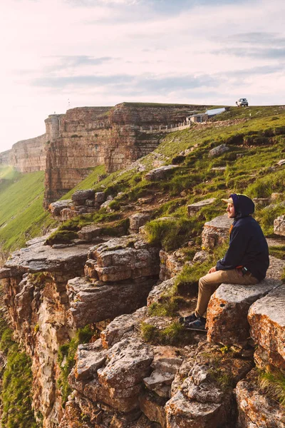 Hombre de viaje turista solo en el borde del Cáucaso roca montañas aventura estilo de vida vacaciones extremas verde puesta del sol paisaje — Foto de Stock