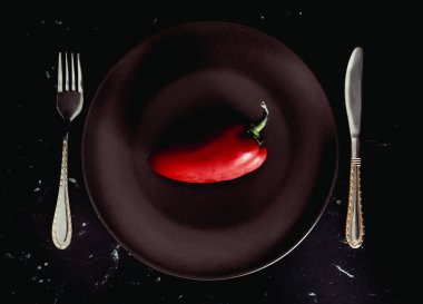 Bir tabakta taze kırmızı biber biber. Diyet. Koyu arka plan.