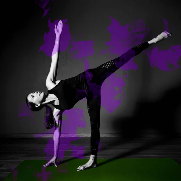 Black white photo of Young beautiful woman brunette in black clothes practice yoga ardha chandrasana in dark studio green mat Purple design element — Stock Photo, Image