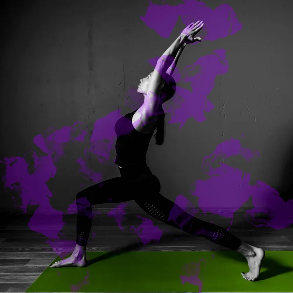 Schwarz-Weiß-Foto von jungen schönen Frau Brünette in schwarzer Kleidung Praxis Yoga virabhadrasana in dunklem Studio grüne Matte lila Design-Element — Stockfoto
