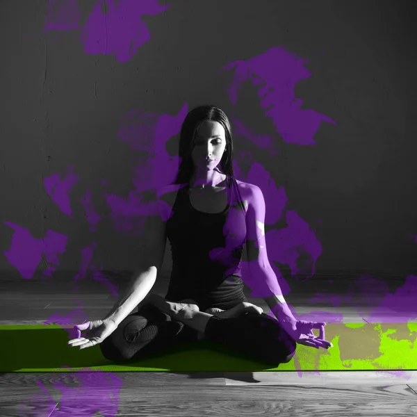 Schwarz Weiß Foto von jungen schönen Frau Brünette in schwarzer Kleidung Praxis Yoga Padmasana in dunklem Studio grüne Matte lila Design-Element Sport und Gesundheitskonzept — Stockfoto