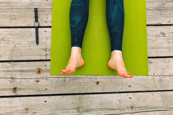 Yoga praktijk. Ontspan Houten vloer. Benen op groen tapijt voor sport. Buiten — Stockfoto