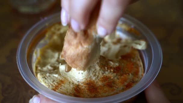 Zbliżenie Żeńskiej Dłoni Trzymającej Świeży Chleb Wymaga Hummusu Zdrowe Wegańskie — Wideo stockowe